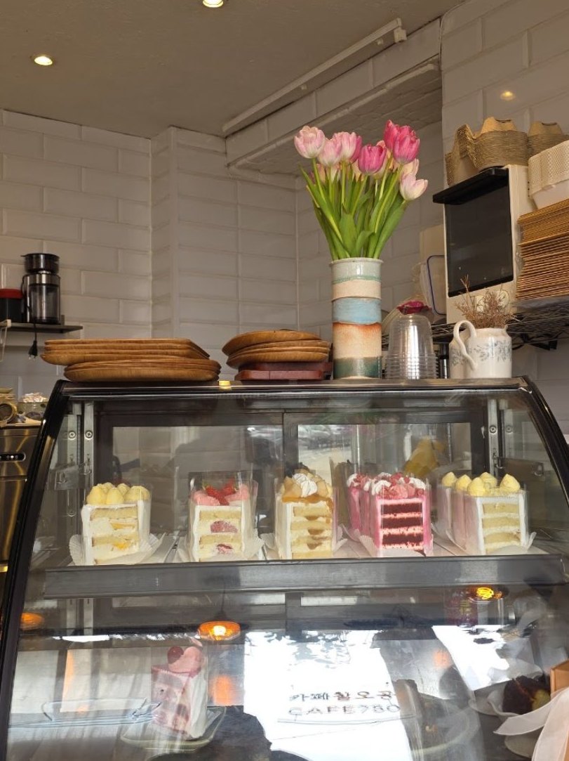 Le comptoir en carrelage hexagonal blanc, la vitrine et un bouquet de tulipes