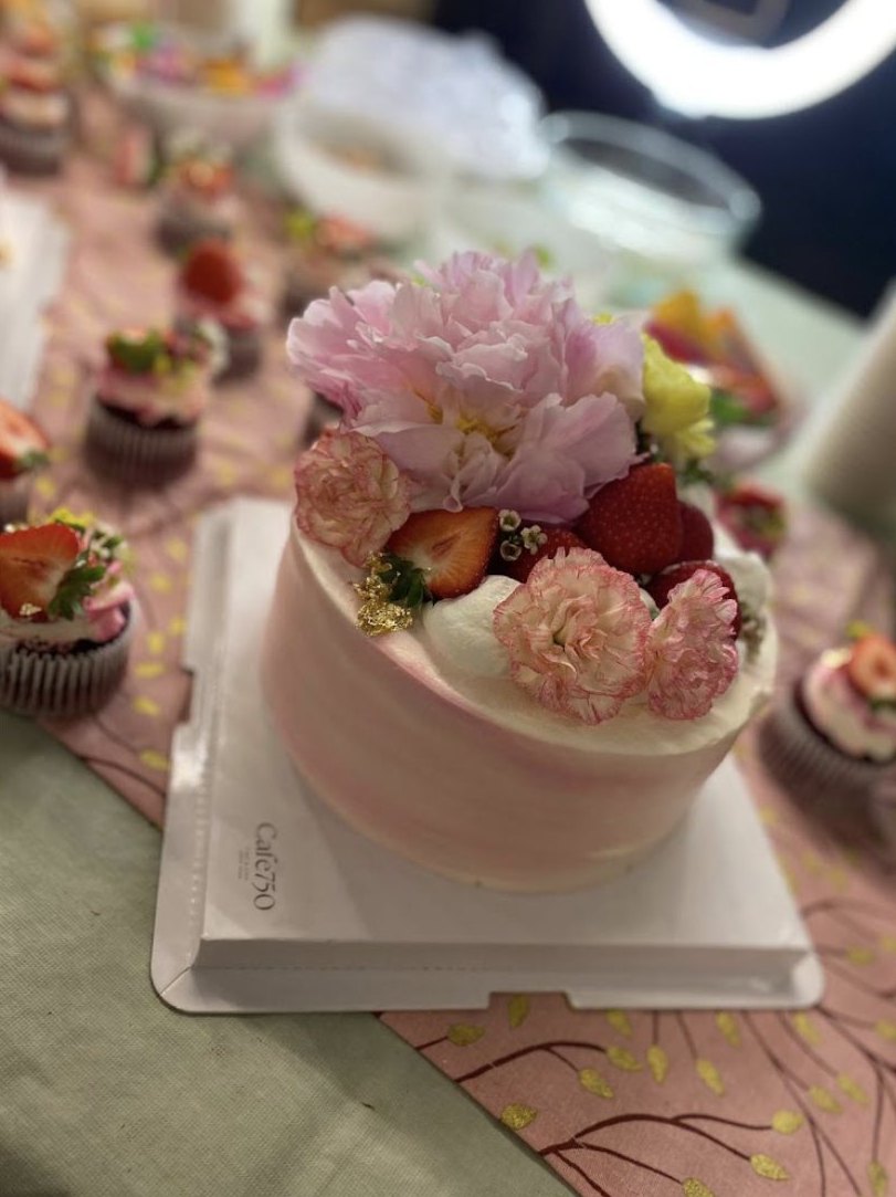 Gâteau rose garni de fraises, d’œillets et d’une pivoine